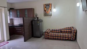 Una sala de estar con un sofá y un refrigerador. en Vrinda Homestay, en Vrindāvan 4 fotos más