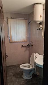 un baño con inodoro y lavabo en Vrinda Homestay, en Vrindāvan