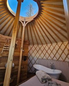 uma casa de banho com uma tenda, uma banheira e uma janela. em MonvisoRelax em Ostana