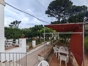 a patio with a table and chairs and a red umbrella at Casa Ferraro in Marina Grande di Capri