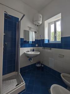 a blue and white bathroom with a sink and a shower at Casa Ferraro in Marina Grande