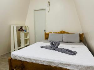 a bed with a stuffed animal on top of it at travis homestay in Siquijor