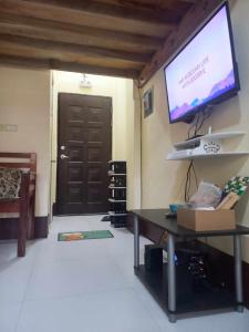 sala de estar con TV, mesa y puerta en Condo for Rent - Cagayan de Oro, en Cagayan de Oro