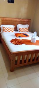 a bed with a wooden frame with two towels on it at Best Homestay in Naivasha