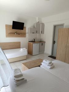 a white room with two beds and a kitchen at Milies in Stavros