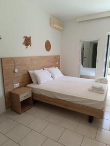 a bedroom with a large bed with a wooden headboard at Milies in Stavros