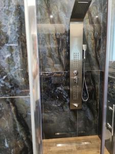 a shower in a bathroom with a stone wall at Elais Luxury Villas in Parga