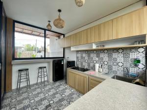 - une cuisine avec un comptoir et quelques tabourets dans l'établissement Luana Villa Ubud, à Ubud