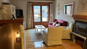 a living room with a couch and a fireplace at Terrazas del Pirineo en Villanúa in Villanúa