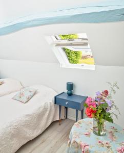 um quarto com uma cama e um vaso de flores sobre uma mesa em Gîte de charme, grand confort em Marolles-sous-Lignières