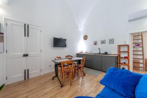 a living room with a table and a kitchen at San Biagio Apartment Lecce in Lecce