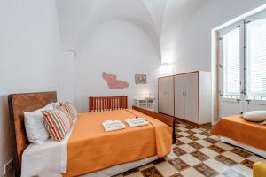 a bedroom with two beds and a couch at San Biagio Apartment Lecce in Lecce