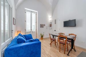 a living room with a blue couch and a table at San Biagio Apartment Lecce in Lecce