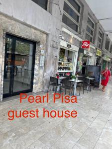 un restaurante con una pizzería en una calle en Pearl Pisa guest house, en Pisa