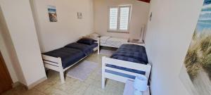 a small room with two beds and a couch at Holiday home Blue 40 m from beach in Kruševo +39 photos