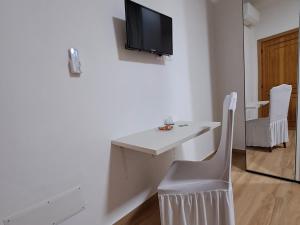 einen weißen Schreibtisch mit einem TV an der Wand in der Unterkunft Villa Andres in Sassari