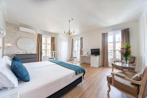 a bedroom with a large white bed and a chair at Hotel Infanta Isabel by Recordis Hotels in Segovia