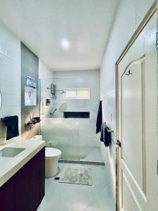 a bathroom with a shower and a toilet and a sink at Pastora House Luxe Staycation Bauan Batangas in Bauan