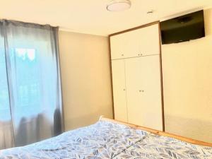 TossenserdeichにあるFerienwohnung 5150 in Tossensのベッドルーム1室(ベッド1台、キャビネット、窓付)