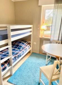 TossenserdeichにあるFerienwohnung 5150 in Tossensの二段ベッドとテーブルが備わる小さな客室です。 +9枚の写真