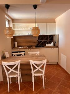 Kalpic Suites & Villa في لازوفاك: مطبخ مع طاولة خشبية وكرسيين