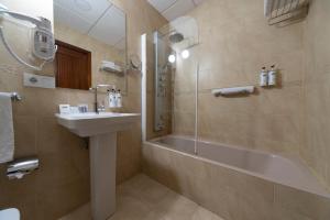 a bathroom with a sink and a tub and a shower at Hotel Infanta Isabel by Recordis Hotels in Segovia +37 photos
