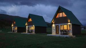 une grande maison en bois avec un toit vert la nuit dans l'établissement Family Farm Pejovic, à Žabljak