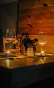 deux verres de vin sur une table avec une bouteille de vin dans l'établissement Family Farm Pejovic, à Žabljak 13 autres photos