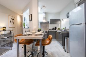 une cuisine avec une table avec des chaises et un réfrigérateur dans l'établissement Le Canopé - Duplex Confort, Hypercentre, 2 Salles d'eau, à Castres