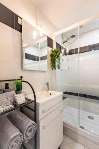 une salle de bain blanche avec un lavabo et une douche dans l'établissement Le Canopé - Duplex Confort, Hypercentre, 2 Salles d'eau, à Castres 31 autres photos