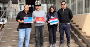 a group of people standing on steps holding up signs at Tagaytay Karakol Hotel in Karakol