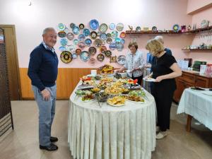 a group of people standing around a table with food at Tagaytay Karakol Hotel in Karakol