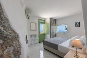 a bedroom with a bed and a green door at Zatrikion Santorini Villas in Pirgos