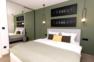 une chambre avec un grand lit blanc et des murs verts dans l'établissement Villa Barovic - Premium apartment, à Mlini