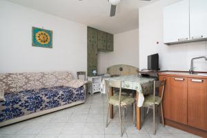 een keuken en een woonkamer met een tafel en een bank bij Monolocale San Giovanni Posada in San Giovanni +12 foto's