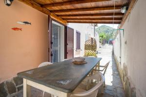 een houten tafel en stoelen op een terras bij Monolocale San Giovanni Posada in San Giovanni