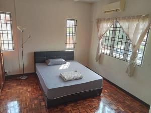 a bedroom with a bed in a room with windows at Taman Sunway Tunas in Bayan Lepas