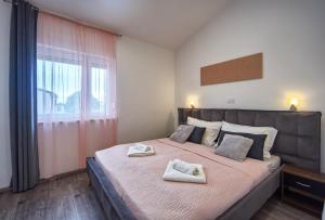 a bedroom with a large bed with two towels on it at Apartments LAURA in Fažana