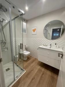 a bathroom with a shower and a toilet and a sink at Faro de Laxe - Pisos Turísticos in Laxe +54 photos