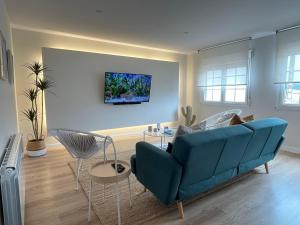 a living room with a blue couch and a table at Faro de Laxe - Pisos Turísticos in Laxe