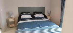 1 dormitorio con 1 cama con 2 mesitas de noche en Le beau séjour, en Pontorson