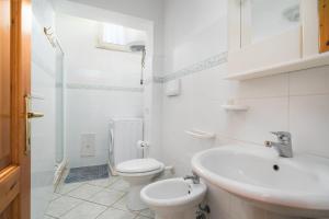 une salle de bains blanche avec toilettes et lavabo dans l'établissement Casa Vacanza San Giovanni Posada, à San Giovanni 12 autres photos