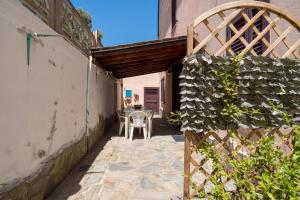 un patio avec une table et des chaises dans un bâtiment dans l'établissement Casa Vacanza San Giovanni Posada, à San Giovanni