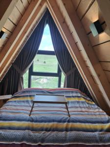 un lit dans une chambre avec une fenêtre dans l'établissement Vila Vuk, à Žabljak