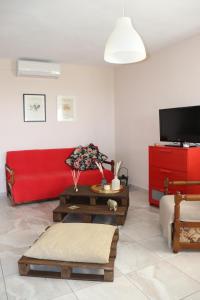 a living room with a red couch and a table at Lia's studio in Skotina