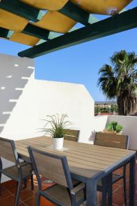 een houten tafel en stoelen op een patio bij Quinta do Morgado - Apartamentos Turisticos Monte Da Eira in Tavira