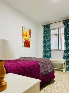 1 dormitorio con cama morada y ventana en Casa El Potrero, en Mocanal