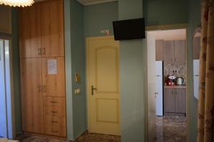 a room with a door and a tv on the wall at Stamoulis Apartments in Agia Effimia