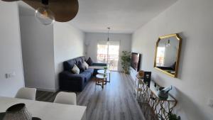 a living room with a blue couch and a table at Apartamento céntrico de estilo nórdico in Adeje