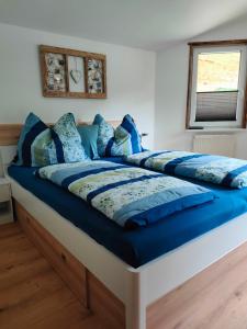 a bed with blue comforter and pillows on it at Haus Jakob in Filzmoos